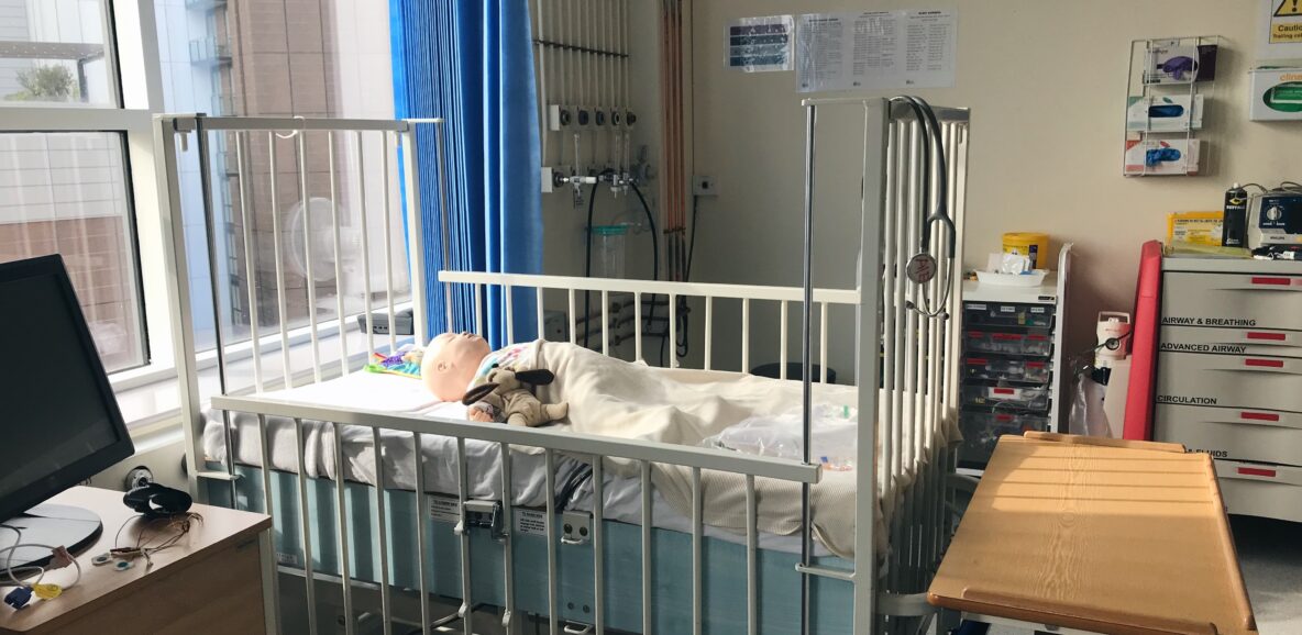 Baby manikin in cot